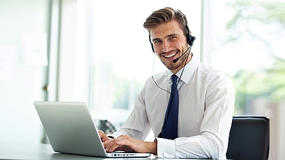 Web Seminars for Spectrum Training Trainer with headset and laptop representing online seminars and digital training.